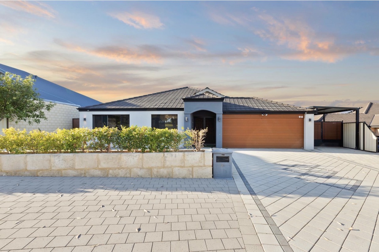 Modern single-storey home with clean exterior and driveway at sunset